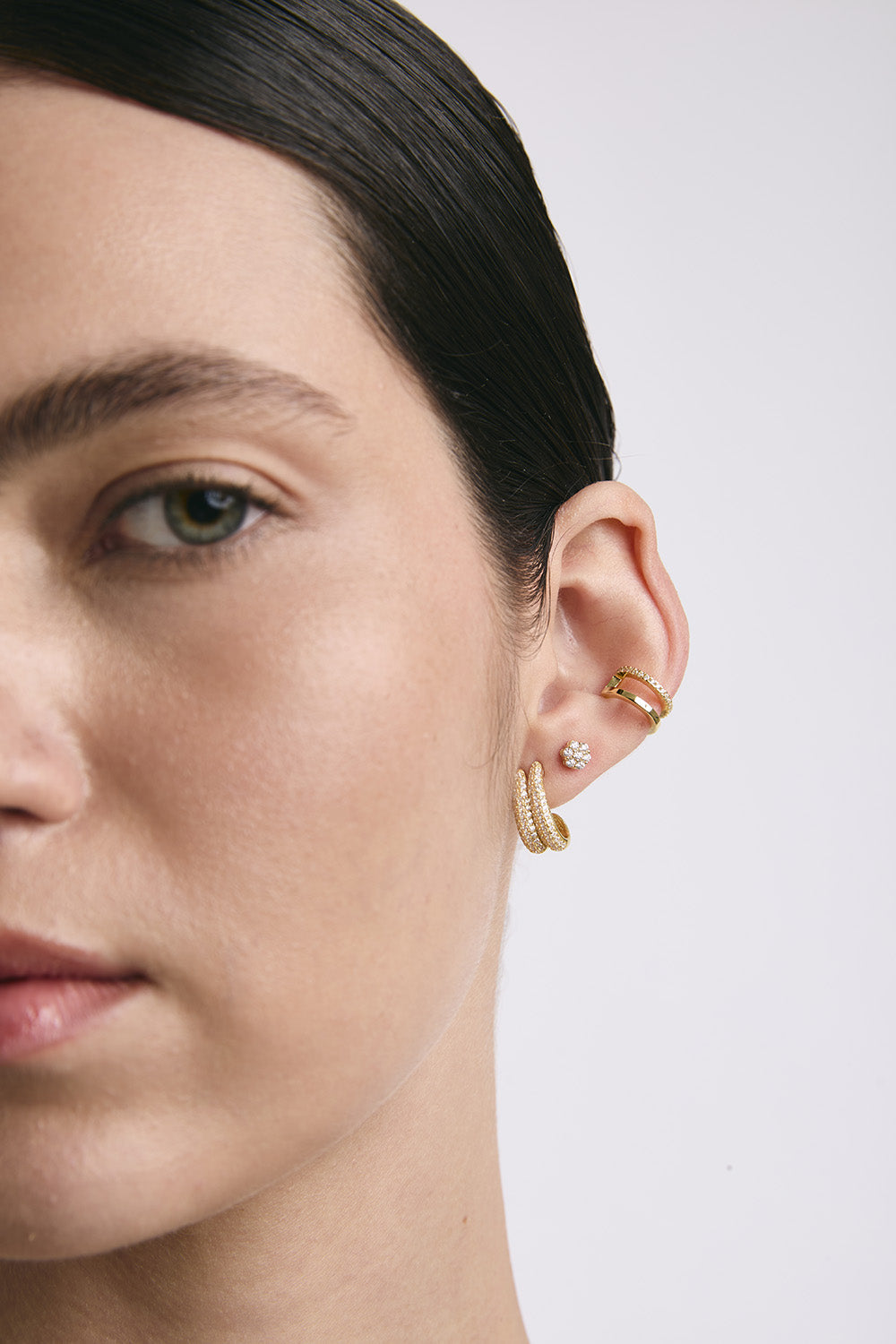 Mujer usa tres pares de aretes.