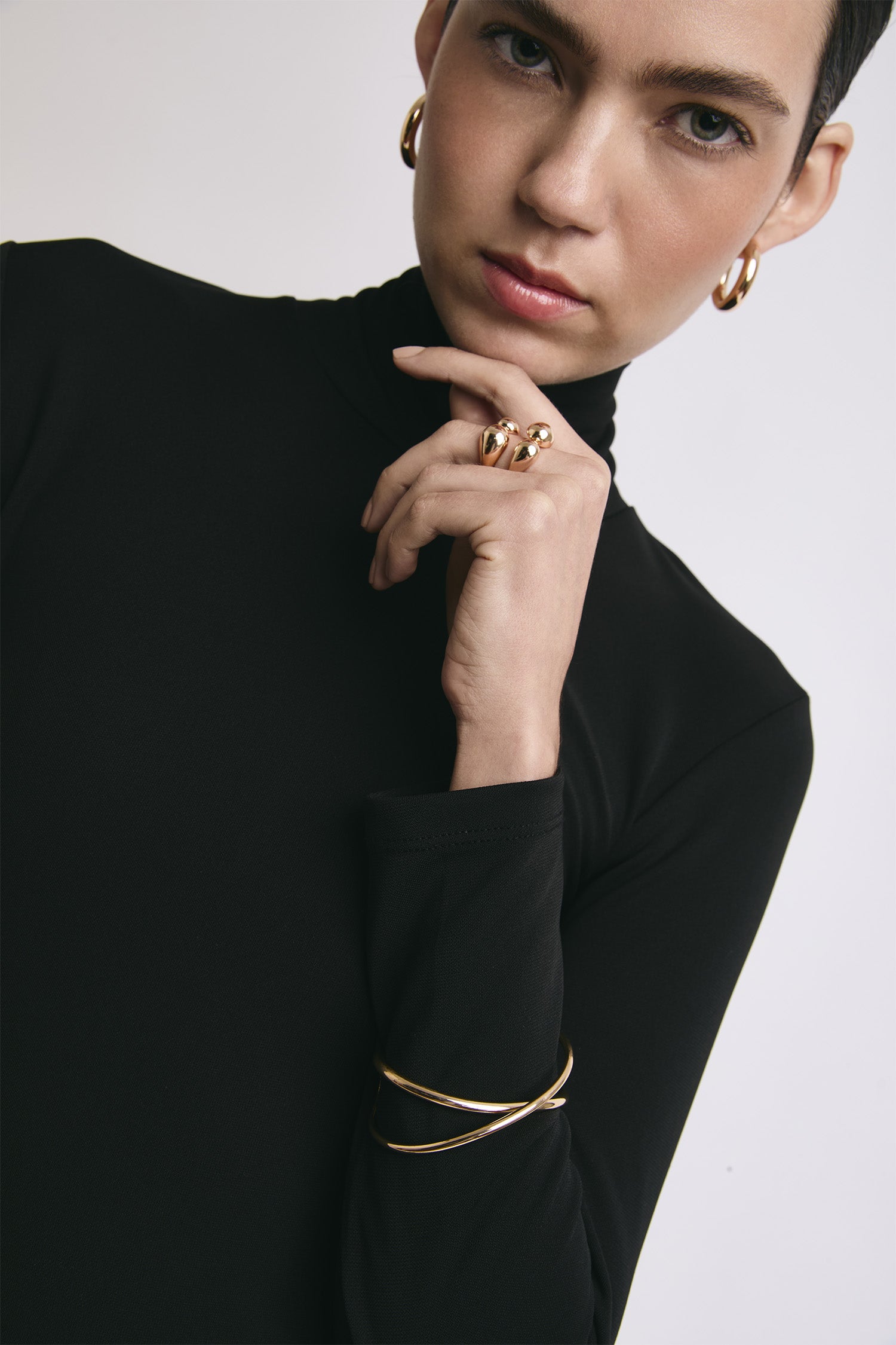 Una chica usando unas pulseras, anillos y aretes Join.