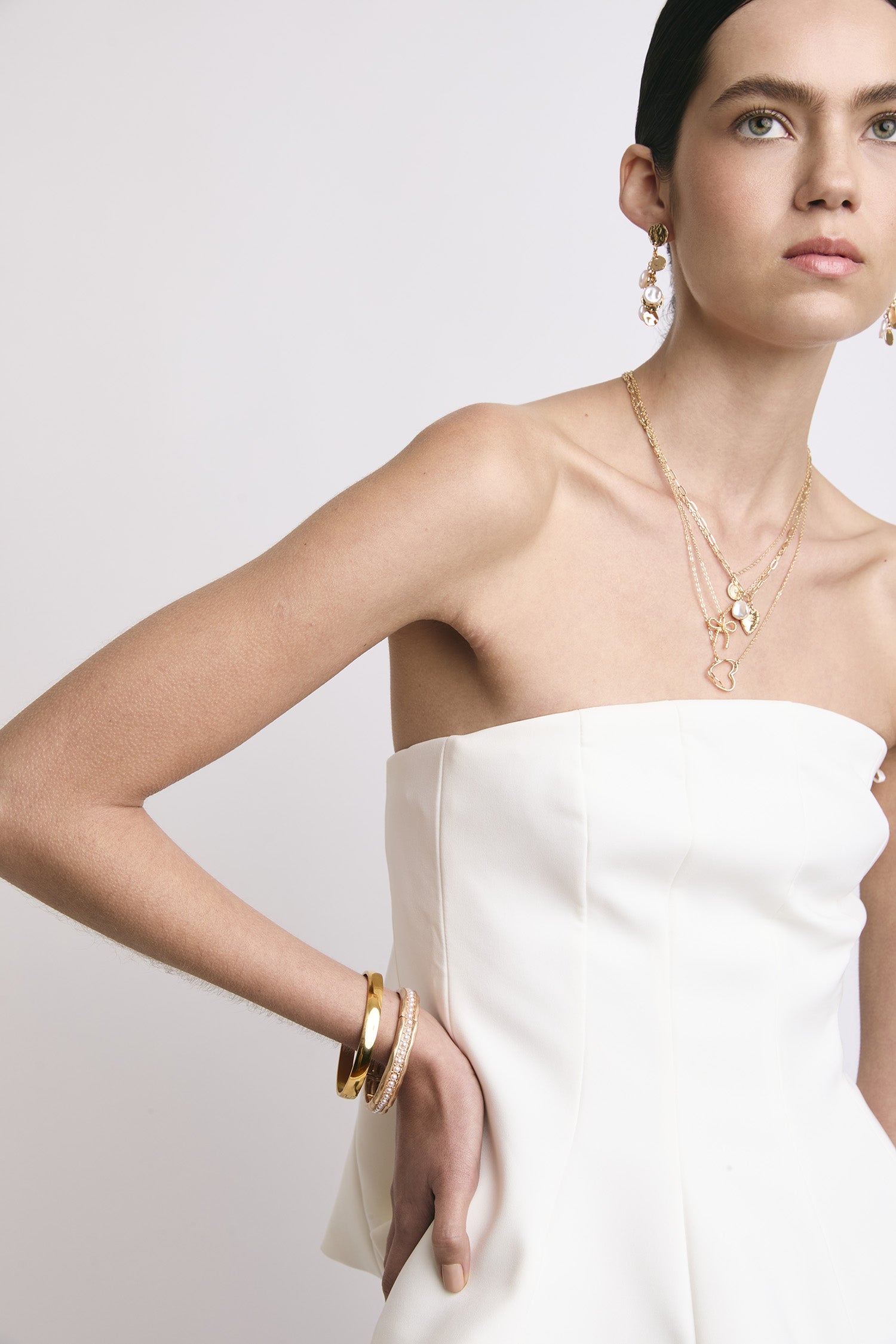 Una chica usando un par de pulseras, collares y aretes Join. 