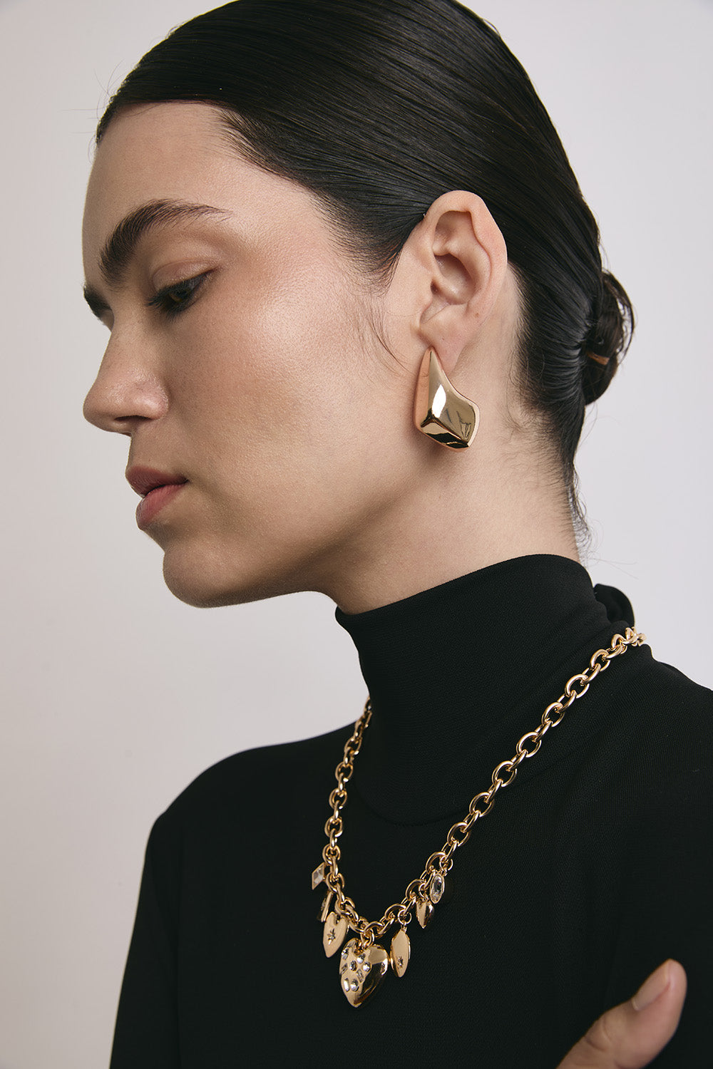 Una chica usando unos aretes y collar Join. 